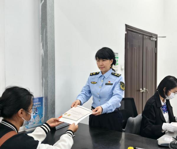 2026年2月6日，广州白云区市场监管局副局长孔丽雅(中)在帮助市民办理营业执照。(受访者供图) 