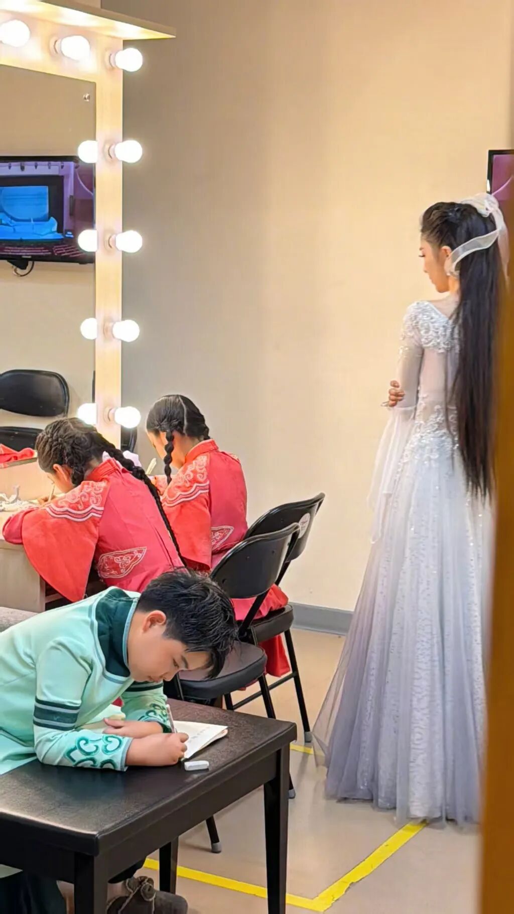 佟丽娅穿着仙女裙 在演出后台给孩子报听写
