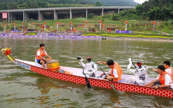 6月19日,四川巴中中华龙舟大赛赛事活动上,两台机器人与龙舟队员并肩划桨,绕场巡游表演。(巴中市委宣传部供图)
