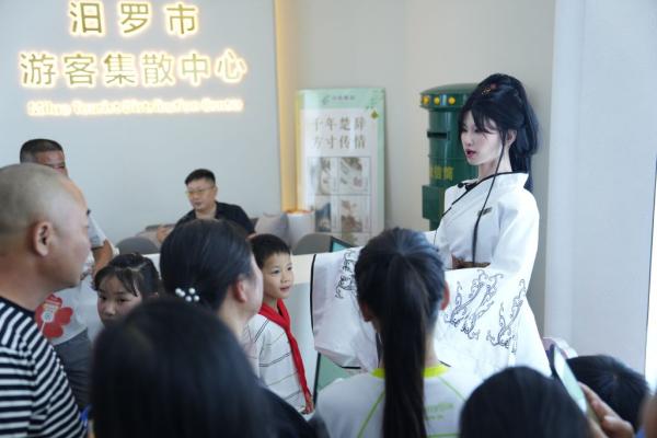 这是女嬃主题仿生机器人(右一)在湖南省汨罗市游客集散中心与游客互动。新华社记者薛宇舸 摄